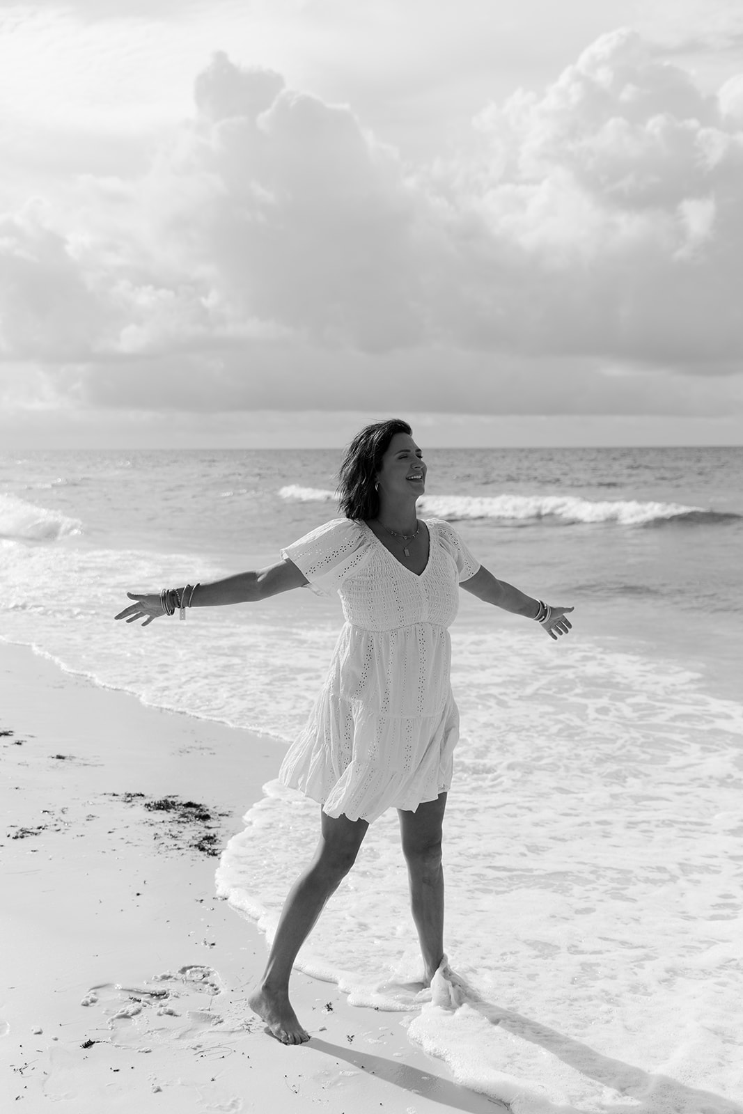 Casey Graham Russell walking barefoot along the shoreline, arms open
